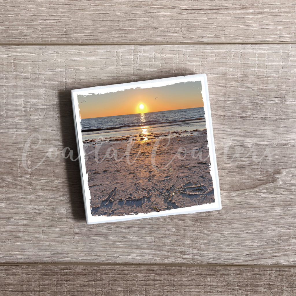 Love written in the sand with sunset